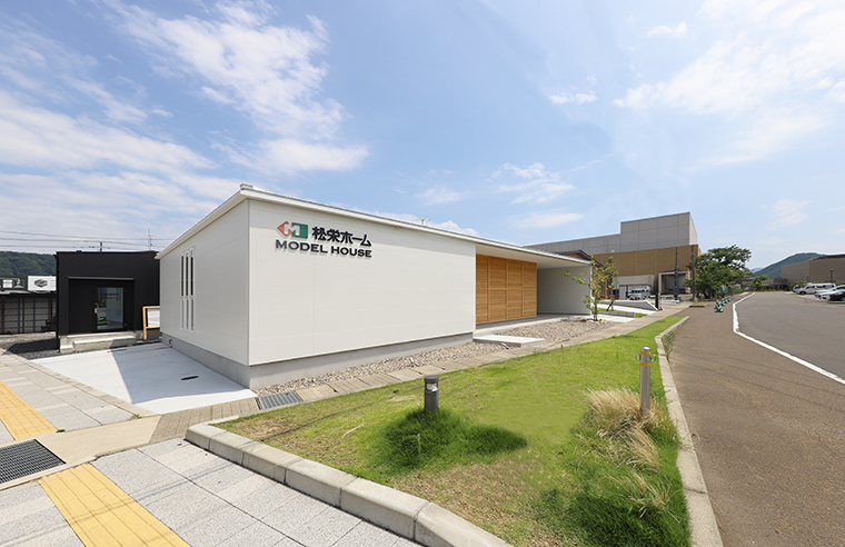 白い外壁と木部を組み合わせた丹南展示場の外観